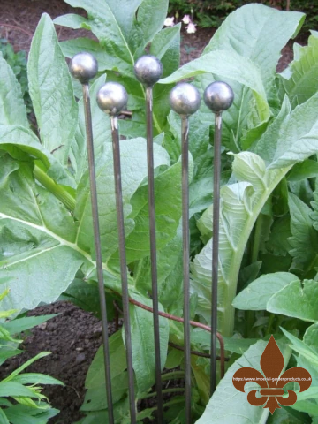Handmade naturally rusting metal ball stake with spherical finial for garden borders.